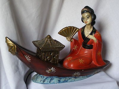 Lady chalkware figurine on canoe