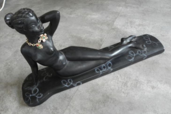 Lying down girl black chalkware figurine