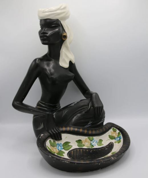 A kneeling lady with a large bowl and head scarf